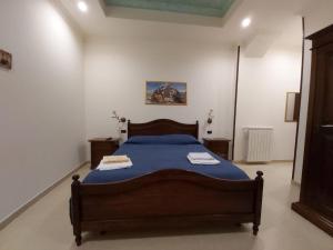尼科泰拉B&B il Baglio的一间卧室配有一张带蓝色棉被的床