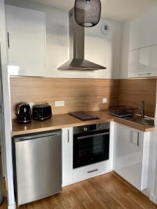 阿雅克修T2 Ajaccio vue mer的厨房配有白色橱柜和炉灶烤箱。