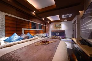横滨HOTEL ZEN KOHOKU的一间卧室配有一张大床和一台平面电视