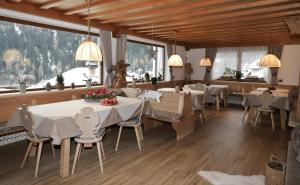 圣克里斯蒂娜Garnì Cir的用餐室配有桌椅和大窗户