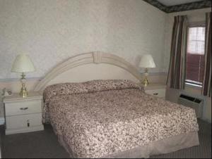 莫里斯普莱恩斯帕西帕尼套房酒店 的一间卧室配有一张床和两个带灯的床头柜