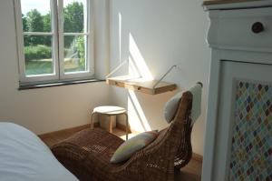那慕尔Gîte Bord de Meuse的一间卧室设有一张床铺和一张椅子,毗邻壁炉