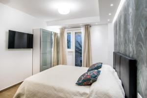 杜布罗夫尼克Dubrovnik Spectrum Rooms的一间卧室配有一张床,墙上配有电视