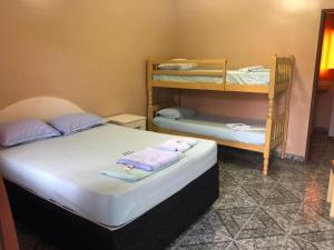 里约达欧特拉斯Pousada Beira Mar的一间卧室配有两张床和一张双层床。