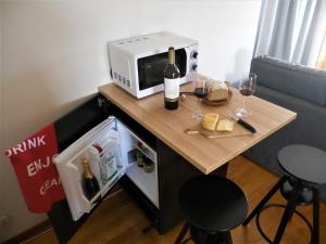 辛特拉Galo Preto - Amazing breakfast Sintra - View and Silence的一张小桌子,上面配有微波炉和酒杯