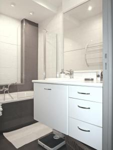 尼斯公寓的白色的浴室设有水槽和浴缸。