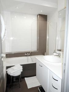 尼斯公寓的一间带水槽、浴缸和镜子的浴室