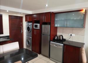 莫塞尔湾Nautica Flat 301的厨房配有不锈钢用具和木柜