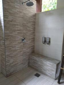 甘地达萨卡迪达莎罗摩辛塔酒店的带淋浴的浴室(带石墙)