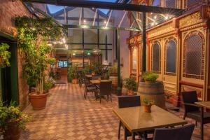昆斯克利夫威尔格兰德酒店的一间设有桌椅和盆栽的餐厅