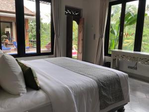 乌布Puri Kasih Gottlieb的卧室设有一张带窗户的白色大床