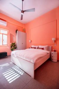 特拉维夫Glamorous Pink Pearl Studio/Beach/Parking/Netflix的一间卧室拥有橙色的墙壁和一张大床