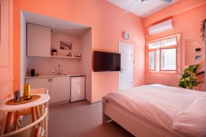 特拉维夫Glamorous Pink Pearl Studio/Beach/Parking/Netflix的一间卧室配有一张床、一张桌子和一个水槽