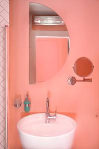 特拉维夫Glamorous Pink Pearl Studio/Beach/Parking/Netflix的浴室设有白色水槽和镜子