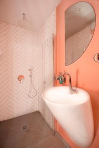特拉维夫Glamorous Pink Pearl Studio/Beach/Parking/Netflix的浴室设有白色水槽和镜子