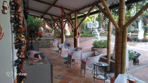 拉米萨Casa guadua piscina privada的一个带白色椅子的庭院,位于木制凉棚下