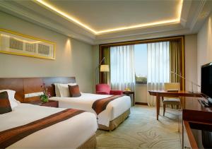 杭州杭州索菲特西湖大酒店的酒店客房配有两张床和一张书桌