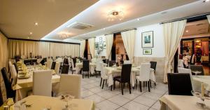 博萨曼努酒店 的一间设有白色桌椅的用餐室