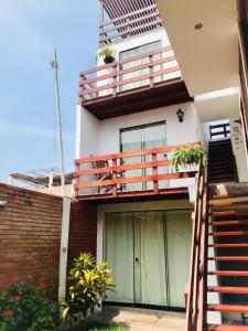 卢林Casa de Playa Arica的带阳台、楼梯和鲜花的房子