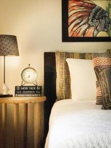 CorralesMorning Star Bed & Breakfast of Corrales的一间卧室配有一张床和一张桌子上的闹钟
