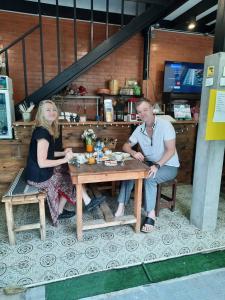 曼谷绿柚木房旅馆的坐在木桌旁的男人和女人