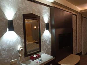 台中市心圆精致汽车旅馆的浴室的墙上设有两盏灯和一面镜子