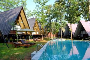 达瓦拉维Kottawatta River Bank Resort的一座带游泳池和部分建筑的度假村