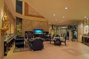 梭罗英达宫索罗酒店的大堂设有椅子、电视和桌子