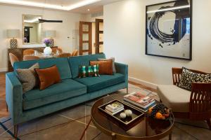 伦敦仕骅廷格洛斯特公园酒店公寓的客厅配有蓝色的沙发和桌子