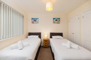 韦斯特沃德霍West Beach - Holiday Apartments的配有白色床单的客房内的两张床