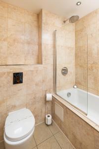 韦斯特沃德霍West Beach - Holiday Apartments的浴室配有卫生间、淋浴和浴缸。