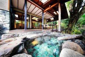 伊豆之国市Yumeguri no Yado Yoshiharu的房屋后院的热水浴池