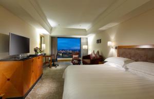 台中市台中金典酒店的配有一张床和一台平面电视的酒店客房