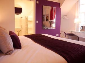 GuestlingGuestling Hall Hotel的一间卧室设有一张紫色墙壁的大床