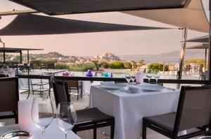 卡尔维La Villa Calvi的餐厅配有白色桌椅和酒杯