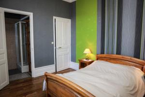 默兹河畔凡尔登La Dragée Hôte, Chambres chez l'habitant的一间卧室设有一张床和绿色的墙壁