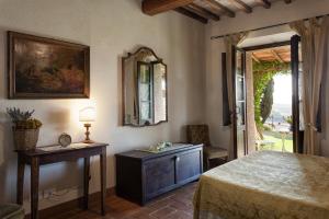 蒙塔尔奇诺Agriturismo MONSOLE - Montalcino的卧室配有一张床,墙上设有镜子