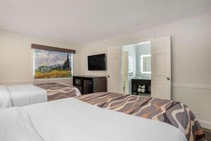 蒙哥马利Baymont by Wyndham Montgomery AL的酒店客房设有两张床和电视。