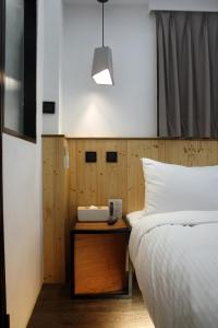 台北正旅馆 (信义)的一间卧室配有一张床和一张桌子及电话