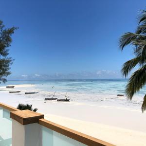 吉汶瓦Ocean View Junior Suite Tatu ZanzibarHouses的享有海滩和水中船只的景色