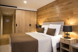 克拉尼斯卡戈拉Korona, Resort & Entertainment的卧室设有白色大床和木墙