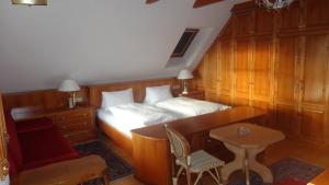 格拉茨希思恩霍夫酒店的一间卧室配有一张床、一张桌子和一张桌子