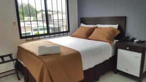 圣萨尔瓦多塔苏马尔酒店的一间卧室设有一张大床和一个窗户。