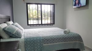 圣萨尔瓦多塔苏马尔酒店的一间卧室配有一张带毯子的床和窗户