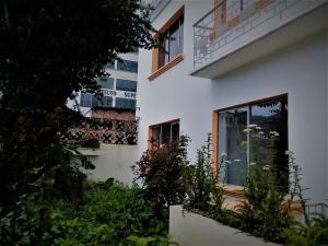 洛哈Villa Amada a place to relax and take a rest的窗户前有植物的白色建筑