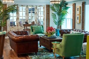 圣西蒙斯岛Hotel Simone的客厅配有棕色皮革家具和绿色椅子