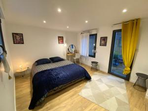 鲁昂Joli appartement avec cour privée proche gare & centre ville的一间卧室配有一张带蓝色棉被的床