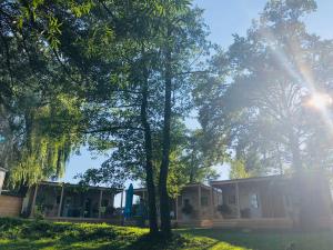 梅特利卡Holiday resort & camping Bela krajina - river Kolpa的前面有树木的房子