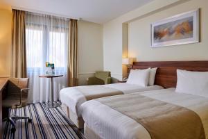 汤顿Holiday Inn Taunton M5, Jct25, an IHG Hotel的酒店客房配有两张床和一张书桌