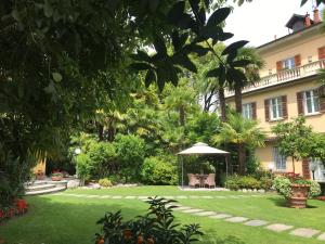 坎诺比奥Villa Palmira Kinderfreies Hotel的一座花园,在一座建筑前设有一个凉亭